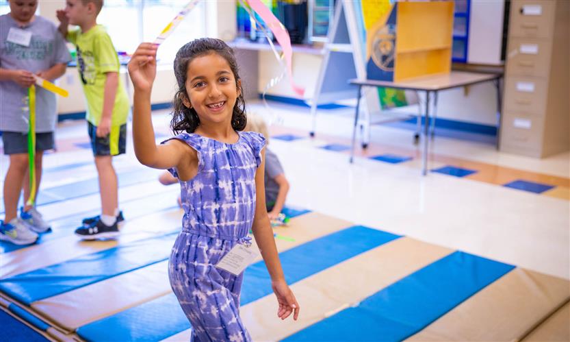 A girl waves a ribbon and dances